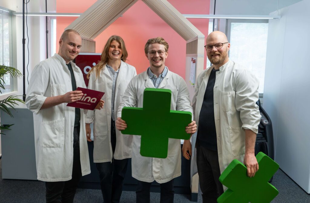 aina Apteekkiklinikan lääkärit rivissä, mukana apteekki-rekvisiittaa
